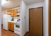 Thumbnail 14 of 44 - a kitchen with white appliances and a wooden door. Fargo, ND Country Edge Apartments