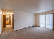 Thumbnail 8 of 44 - the living room of an apartment with a large window and carpeting. Fargo, ND Country Edge Apartments