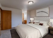 Thumbnail 5 of 16 - a bedroom with a large bed and a door to a bathroom. Fargo, ND Crescent Park Apartments