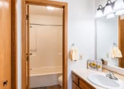 Thumbnail 13 of 16 - a bathroom with a sink and a shower and a mirror. Fargo, ND Crescent Park Apartments