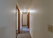 Thumbnail 16 of 16 - the upstairs hallway of a house with a carpeted floor and wooden doors. Fargo, ND Crescent Park Apartments