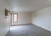 Thumbnail 6 of 16 - an empty living room with carpet and a window. Fargo, ND Crescent Park Apartments