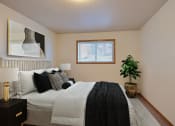 Thumbnail 3 of 10 - Fargo, ND Dakota Manor Apartments. a bedroom with a large bed and a plant in the corner of the room