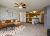 Thumbnail 2 of 11 - Fargo, ND Danbury Apartments. a living room with a couch a table and a ceiling fan