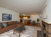 Thumbnail 2 of 12 - Fargo, ND Dynasty Apartments. a living room with a fireplace and a kitchen in the background