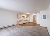 Thumbnail 25 of 28 - the living room and kitchen of an apartment with a carpeted floor. Fargo, ND Eagle Run Apartments