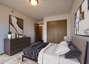 Thumbnail 3 of 28 - a bedroom with a bed and a dresser and a door to a bathroom. Fargo, ND Eagle Run Apartments