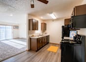 Thumbnail 22 of 28 - the view of a kitchen and living room with a sliding glass door. Fargo, ND Eagle Run Apartments