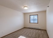 Thumbnail 16 of 28 - a bedroom with carpet and a window. Fargo, ND Eagle Run Apartments