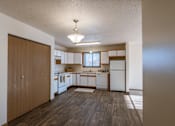Thumbnail 15 of 28 - an empty kitchen with white appliances and a wooden floor. Fargo, ND Eagle Run Apartments