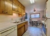 Thumbnail 3 of 12 - A kitchen with wooden cabinets and a white dishwasher. Fargo, ND Emerald Apartments