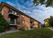 Thumbnail 1 of 12 - a brick building with three levels and a sidewalk in front. Fargo, ND Emerald Apartments