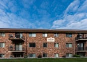 Thumbnail 12 of 12 - a brick apartment building with balconies and a blue sky. Fargo, ND Emerald Apartments