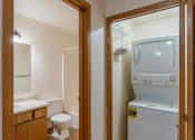 Thumbnail 18 of 19 - a bathroom with a washer and dryer in it and a toilet and sink. Fargo, ND Galleria Apartments