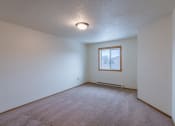 Thumbnail 16 of 19 - a bedroom with white walls and a window. Fargo, ND Galleria Apartments