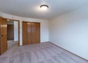 Thumbnail 17 of 19 - a bedroom with white walls and a door to a closet. Fargo, ND Galleria Apartments