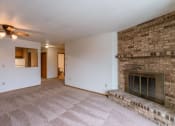 Thumbnail 13 of 19 - an empty living room with a brick fireplace and a ceiling fan. Fargo, ND Galleria Apartments