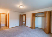 Thumbnail 9 of 19 - the living room of an empty house with a carpeted floor and two closets. Fargo, ND Galleria 3 Apartments