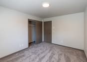 Thumbnail 9 of 24 - A bedroom with carpet and a door to a closet. Fargo, ND Granger Court Apartments.