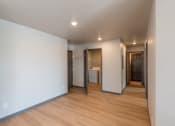 Thumbnail 7 of 24 - A dining room with white walls and wood flooring with a hallway. Fargo, ND Granger Court Apartments.