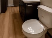 Thumbnail 12 of 24 - A bathroom with a toilet and a sink and a mirror. Fargo, ND Granger Court Apartments.