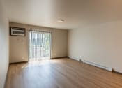Thumbnail 13 of 24 - An empty living room with wood floors and a window. Fargo, ND Granger Court Apartments.