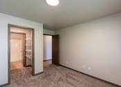 Thumbnail 20 of 24 - A bedroom with a closet and a door to a bathroom. Fargo, ND Granger Court Apartments.
