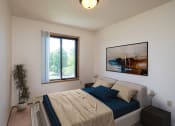 Thumbnail 5 of 14 - a bedroom with a bed and a painting on the wall. Fargo, ND Hazelwood Townhomes