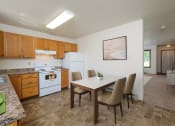 Thumbnail 3 of 14 - a kitchen with white appliances and a dining table with chairs. Fargo, ND Hazelwood Townhomes