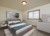 Thumbnail 4 of 9 - Fargo, ND Hunters Run Apartments. A bedroom with a bed, dresser, and large window.