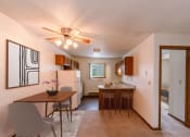 Thumbnail 3 of 13 - a dining room and kitchen with a table and chairs and a ceiling fan. Fargo, ND Huntington Apartments