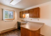 Thumbnail 9 of 13 - A kitchen with a sink and dishwasher with a window. Fargo, ND Huntington Apartments.