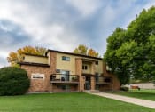 Thumbnail 1 of 13 - An apartment building with a green yard and a cloudy sky.Fargo, ND Huntington Apartments.