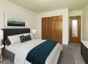 Thumbnail 5 of 34 - Fargo, ND Islander Apartments. A bedroom with a bed and night stands. Theres a medium sized closet for extra storage space.