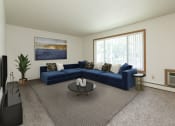 Thumbnail 4 of 34 - Fargo, ND Islander Apartments. A living room with a large blue couch and a coffee table.  A large window brightens the room with natural light