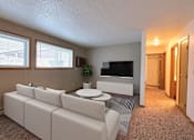 Thumbnail 2 of 20 - a living room with a white couch and a coffee table. Fargo, ND Kennedy Apartments