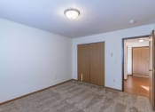 Thumbnail 9 of 49 - a bedroom with a door to the hallway. Fargo, ND Lake Crest Apartments
