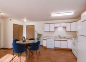 Thumbnail 5 of 49 - a kitchen with white appliances and a table with chairs. Fargo, ND Lake Crest Apartments