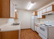 Thumbnail 25 of 49 - a kitchen with white appliances and wooden cabinets and a white stove. Fargo, ND Lake Crest Apartments
