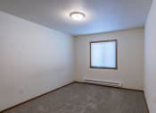 Thumbnail 14 of 49 - the bedroom of an empty house with carpet and a window. Fargo, ND Lake Crest Apartments