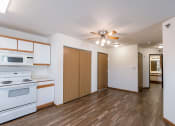 Thumbnail 13 of 49 - an empty kitchen with white appliances and a ceiling fan. Fargo, ND Lake Crest Apartments