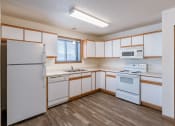 Thumbnail 12 of 49 - an empty kitchen with white appliances and white cabinets. Fargo, ND Lake Crest Apartments