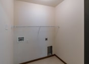 Thumbnail 16 of 49 - a laundry room with a white wall and a door. Fargo, ND Lake Crest Apartments