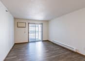 Thumbnail 10 of 49 - an empty living room with wood flooring and a sliding glass door. Fargo, ND Lake Crest Apartments