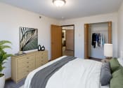 Thumbnail 4 of 49 - Fargo, ND Lake Crest Apartments. A bedroom with a large bed and a dresser with a mirror