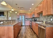 Thumbnail 43 of 49 - Fargo, ND Lake Crest Apartments. A large kitchen with wooden cabinets and stainless steel appliances