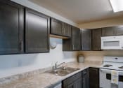 Thumbnail 30 of 49 - Fargo, ND Lake Crest Apartments. A kitchen with a sink stove and microwave