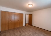 Thumbnail 14 of 30 - A spacious bedroom with carpeted floors a large closet. Fargo, ND Long Island Apartments.