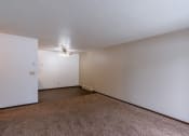 Thumbnail 7 of 30 - An empty living room with carpet and white walls with a dining room in the background. Fargo, ND Long Island Apartments.