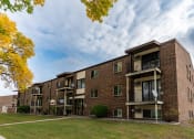 Thumbnail 30 of 30 - A brick apartment building with balconies on a cloudy day. Fargo, ND Long Island Apartments.